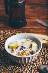 Homemade Granola with Fresh Sliced Pear, Raisins and Milk in Bowl