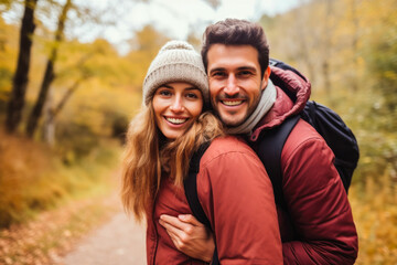 Happy couple piggybacking in a forest in autumn, showcasing love