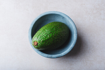 Green Avocado in Blue Bowl