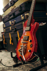 closeup of red guitar on stand with copyspace in rehearsal room. selective focus