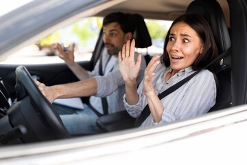 Frightened millennial woman driving car with instructor