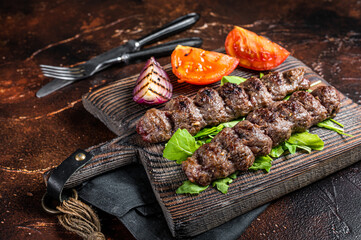 Turkish adana kebab, ground beef and lamb meat grilled on skewers  served with tomato, salad and...