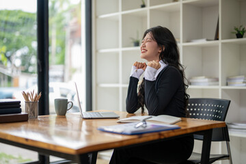 Happy businesswoman celebrates victory while receiving good news while working in modern office. Excited about success