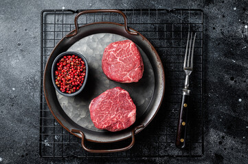 Dry aged Raw steaks fillet Mignon, Beef tenderloin. Black background. Top view