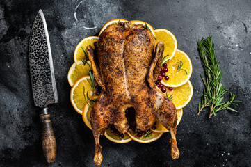 Christmas dinner, baked duck with rosemary and oranges, crispy whole roast duck. Black background....