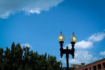 Fototapeta na wymiar Lit lamppost silhouette against blue sky, Boston, USA