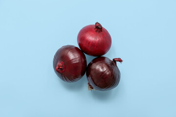 Fresh red onions on blue background