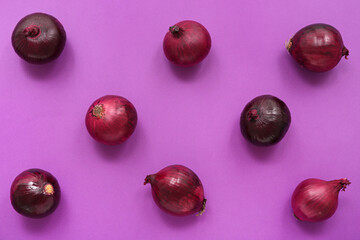 Fresh red onions on purple background