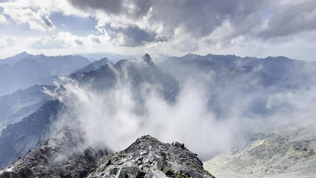 4K aerial footage of misty clouds rising up over Morskie Oko lake early morning in High Tatras mountain range with incredible light and shadows play. Rysy peak 2499m view.