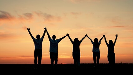 Team of people look at their future together at sunset, park. Group of business people outdoors raise their hands to sky. Human resources. Community of people joint prayer. Unity of group of people