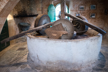 Old mill for grinding olives. An antique machine for producing olive oil.
