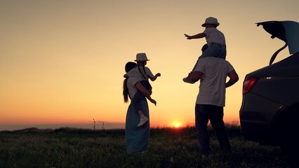 Obraz na płótnie Canvas Dad with child, daughter on his shoulders, mom, children dance and admire beautiful sunset. Parents and children stopped at campsite by car. Happy family travels by car. Big family, Travel by car. Kid