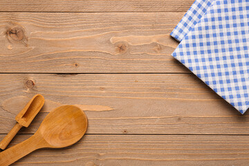 Clean napkins, spoon and scoop on wooden background