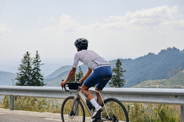 Cyclist training a gravel bike in mountain.Man cyclist  wearing cycling kit and helmet.Empty...