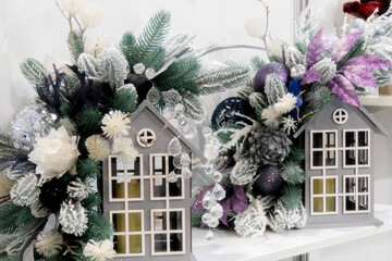 Decorative New Year's candlestick in the shape of a house with Christmas tree decorations.