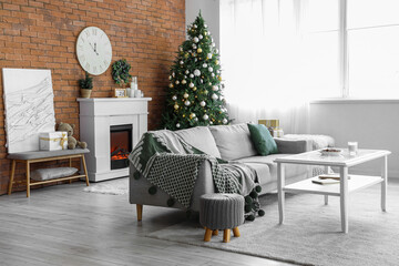 Electric fireplace with Christmas tree and grey sofa in living room