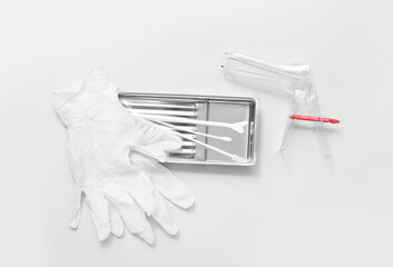 Medical gloves with gynecological speculum and pap smear test tools on light background - obrazy, fototapety, plakaty