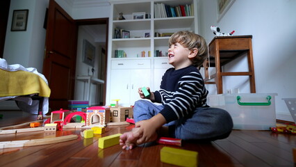 Happy child playing with tower blocks. One small boy putting vintage pieces on top of one another...