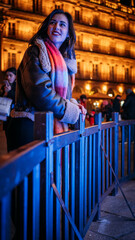 Pretty young girl with scarf admiring the Christmas lights. 