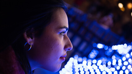 Pretty young girl with scarf admiring the Christmas lights. 