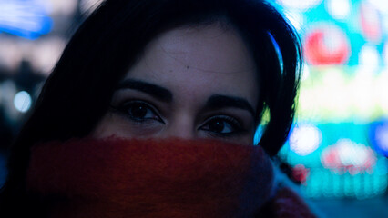 Pretty young girl with scarf admiring the Christmas lights. 