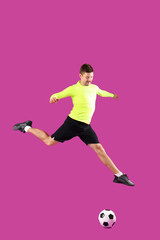 Fototapeta premium Jumping soccer player on magenta background