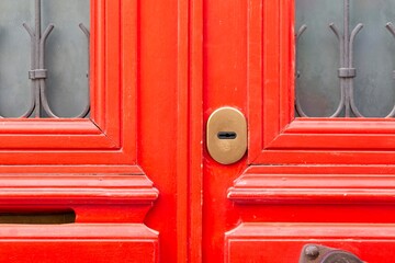 Key lock on a closed red wooden door close up
