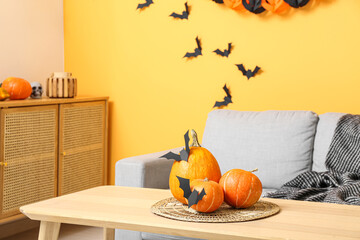 Halloween pumpkins with paper bats on table in living room