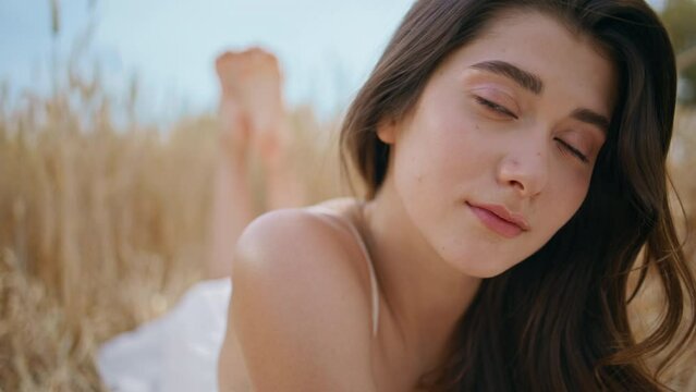 Brunette woman posing field nature portrait. Young barefoot lady relaxing summer