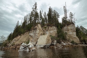 view of the rocky cliff of the river bank from the river side.