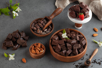 Assorted pieces of chocolate, cocoa beans on a grey background. Handmade chocolate.