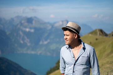 Young man on an alpine hike in the Swiss mountains. He enjoys the beautiful landscape. Alpin mountain panorama