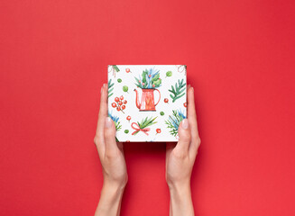 gift box in hands on a red background