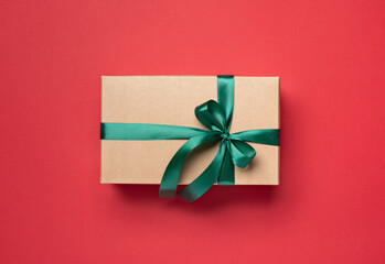 gift box with green ribbon on red background