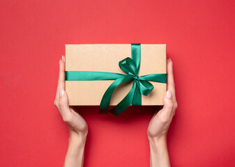 gift box in hands on a red background