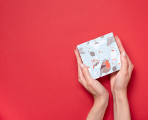 gift box in hands on a red background