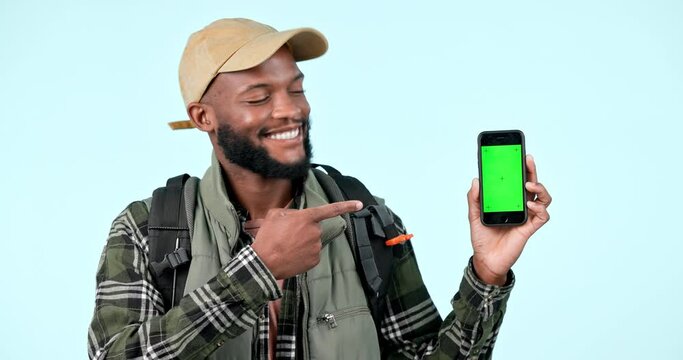 Green screen cellphone, hiking or man point at mobile navigation app, online map or studio mockup space. Happy portrait, tracking markers or black person advertising smartphone GPS on blue background
