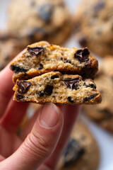 Close-up of chocolate chip cookies cut. A woman's hand holds an American cookie broken in half. Recipe. Selective focus.