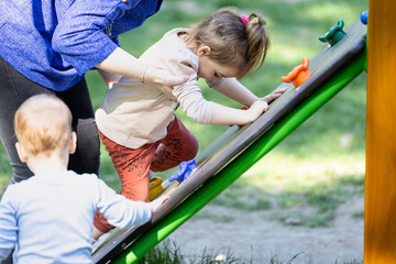 Fototapeta na wymiar Kid learning how to climb in outdoor playground.