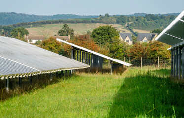 Solar Farm panels,and rural residential buildings in the near distance, the Cotswolds, Gloucestershire,England,United Kingdom.