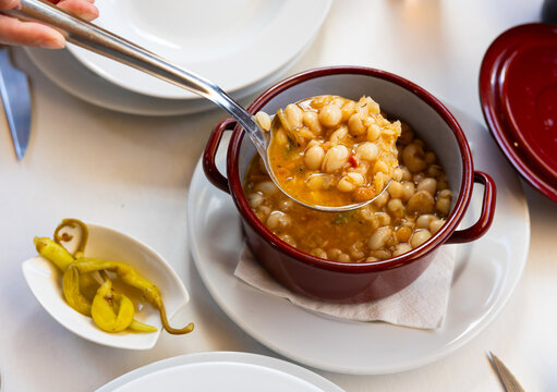 Pochas stewed with vegetables and ham bone in ladle. Aragonese cuisine
