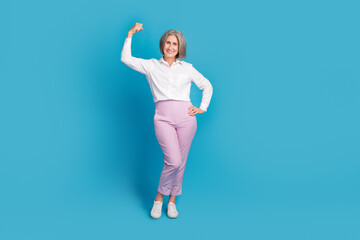 Full length photo of pretty strong lady wear white shirt showing muscles rising fist isolated blue color background