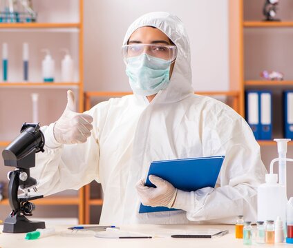 Young biochemist wearing protective suit working in the lab