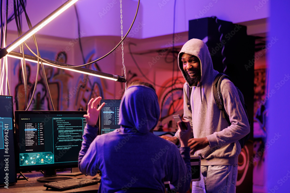 Poster hacker showing ssd containing spyware for phishing attack in abandoned warehouse. internet criminal 