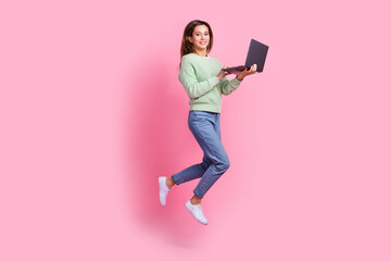 Full size body photo of crazy jumping girl programmer hold netbook new page for wikipedia information isolated on pink color background