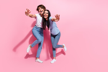 Full length body photo of two young ladies welcome crazy greetings invite black friday shopping mall isolated on pink color background