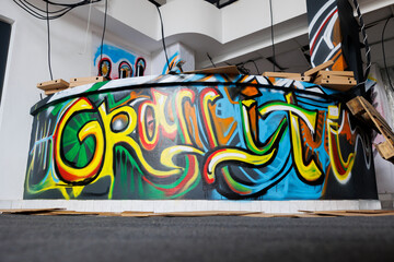 Deserted warehouse in state of ruins crumbling down, looking dirty and abandoned. Empty destroyed urban building with debris and graffiti spray paint artwork, broken bricks and chaos in ghetto.