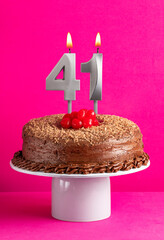 Birthday card with candle number 41 - Chocolate cake on pink background