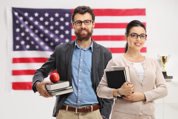Teachers in front of a USA flag holding books
