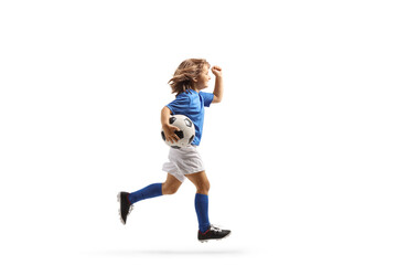 Full length profile shot of a girl in a football kit running with a ball